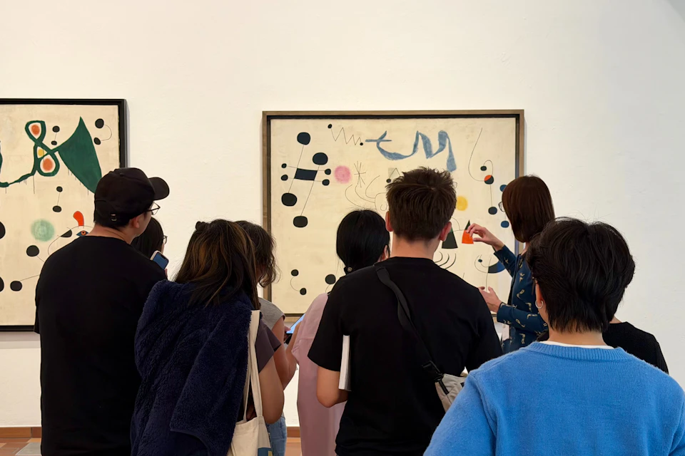 A group of people looking at an abstract painting in a gallery setting.