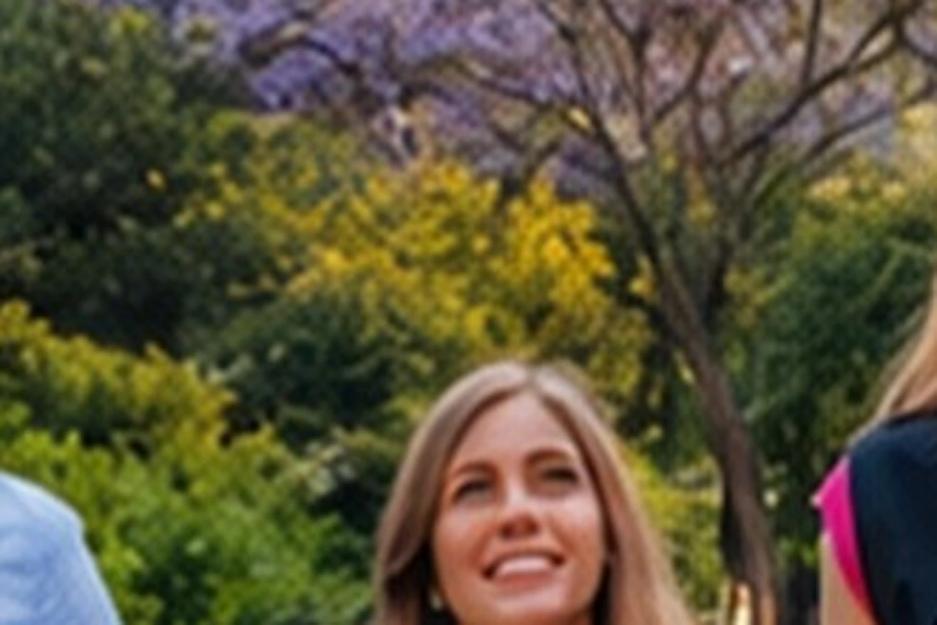 Four people walking towards the camera on a path, with the Sagrada Família basilica prominently in the background.