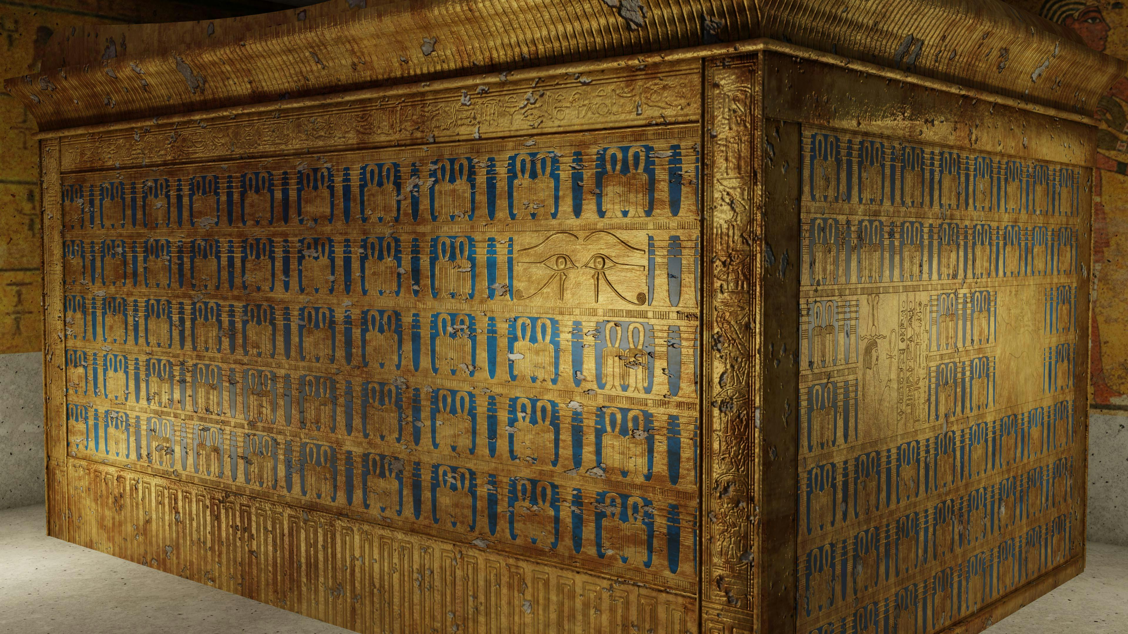 Close-up of an ornate golden sarcophagus adorned with blue hieroglyphs and an eye of Horus symbol in the center.