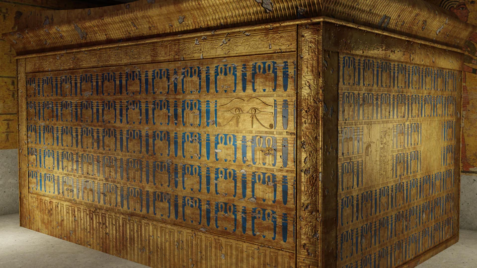 A close-up of an ornate golden sarcophagus decorated with blue hieroglyphs and an Eye of Horus symbol in the centre.