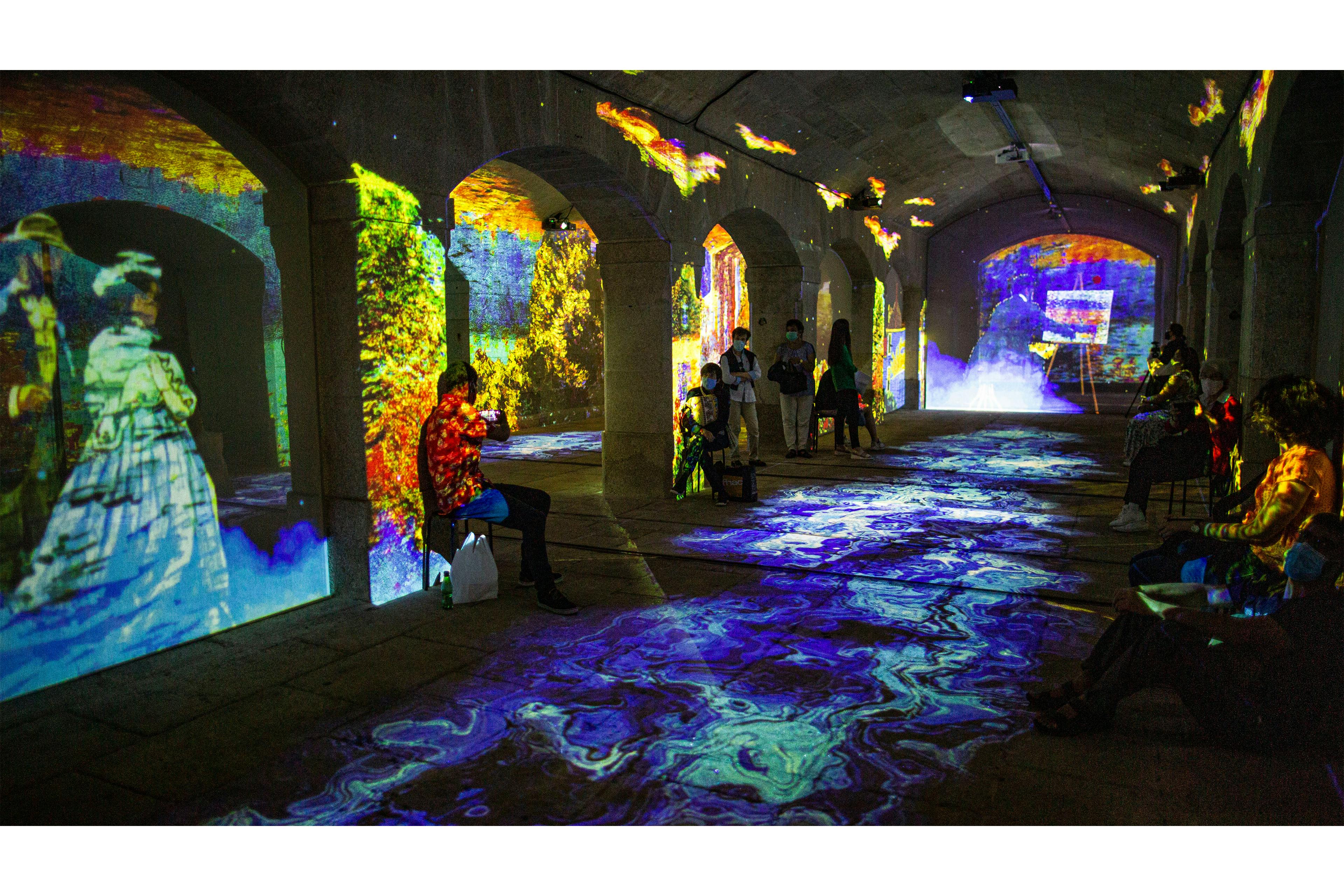 アーチ型の部屋の中には、壁や床にカラフルなデジタルプロジェクションがあり、活気に満ちた没入型の環境を作り出しています。