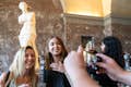 2 Gäste lassen sich vor der Statue der Venus de Milo fotografieren