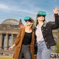 Två flickvänner med VR-glasögon framför riksdagen
