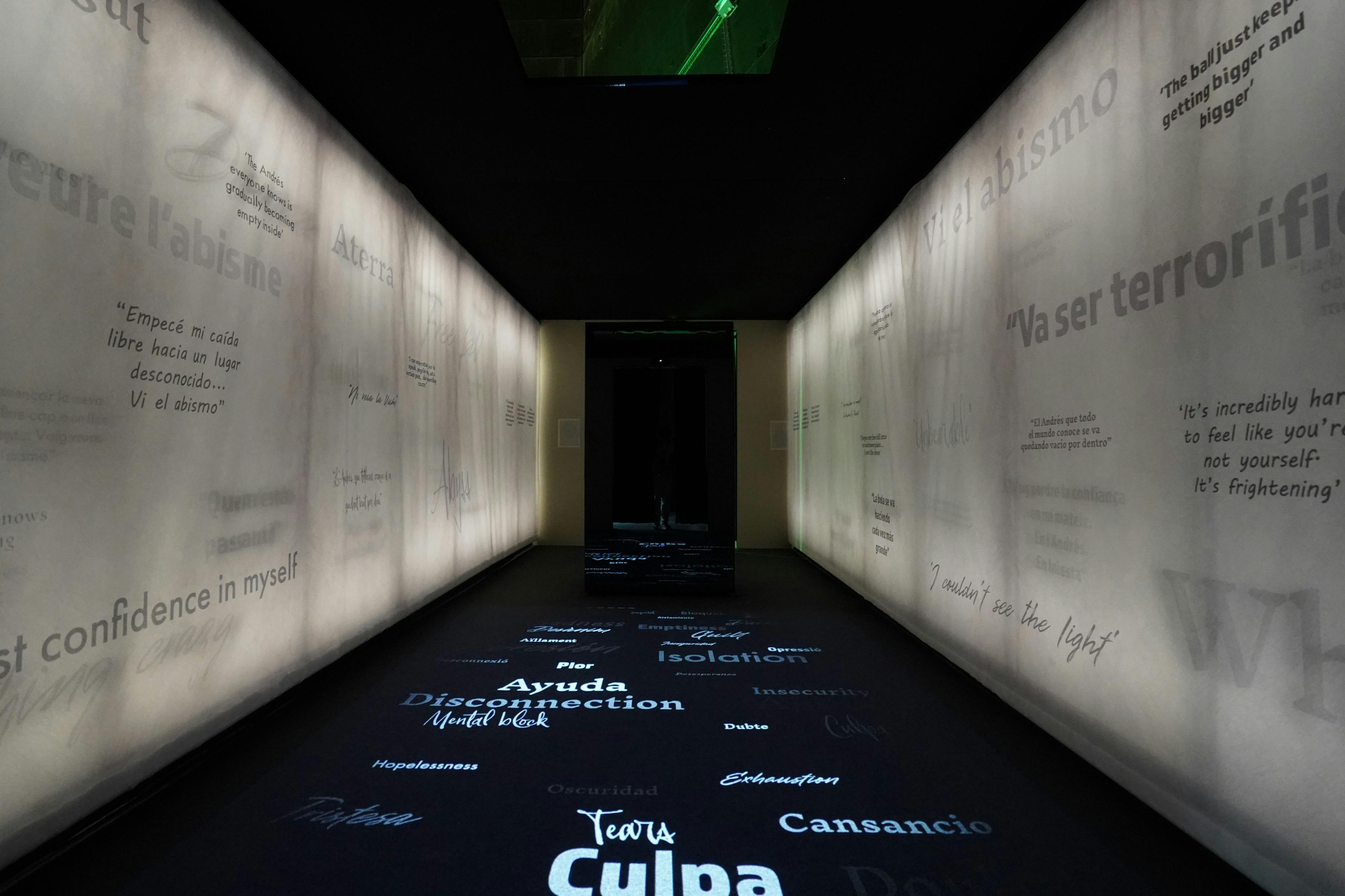A dimly lit hallway with words projected on the floor and walls, creating an immersive atmosphere.