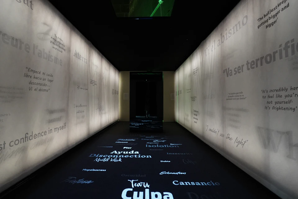 A dimly lit hallway with words projected on the floor and walls, creating an immersive atmosphere.