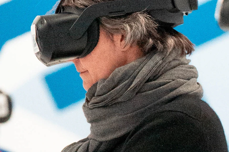 People wearing VR headsets standing in a modern art-themed room with abstract blue and white designs.