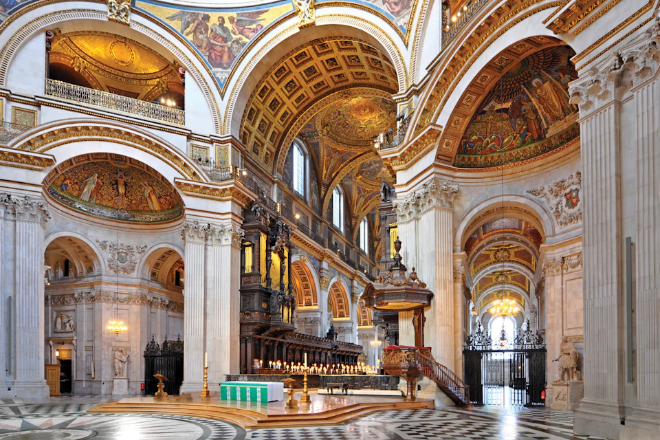 A grand interior of a cathedral with ornate decorations, high arches, detailed ceilings, and a lit altar with candles.