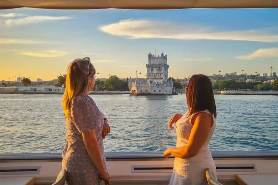 Two women looking at the Belém Tower on a FRS Lisbon Sunset Cruise