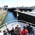 People on the bow of an Argosy boat as it approaches the Locks. Concrete walls are on either side