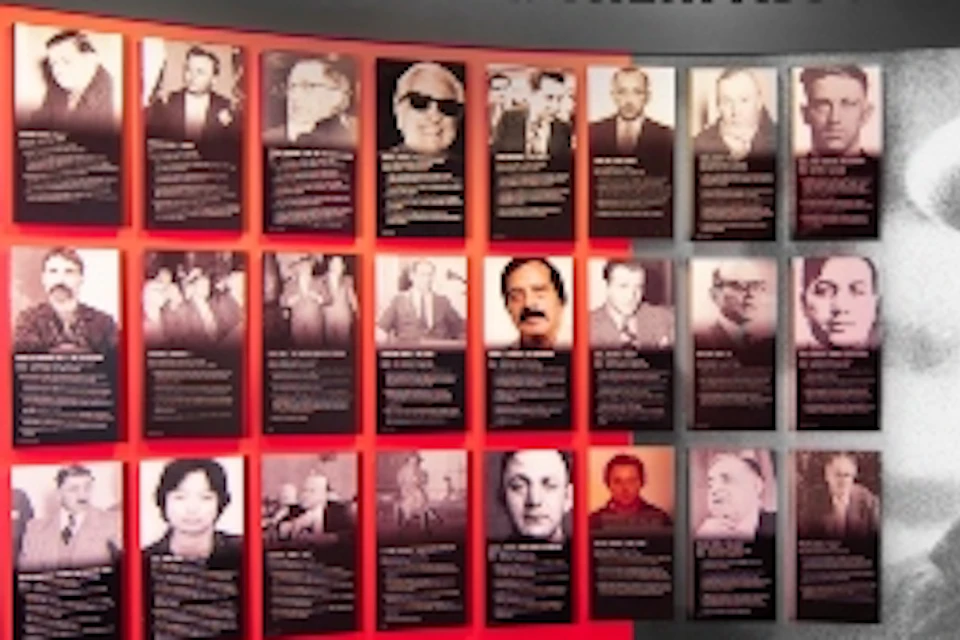 A museum exhibit featuring a large photo of a man in a hat and suit, titled "Made Men & Their Associates," with smaller images and text.
