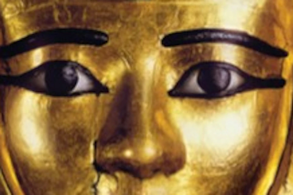 Golden mask of an Egyptian pharaoh with exhibition title 'Ramses and the Pharaohs' Gold' displayed above.