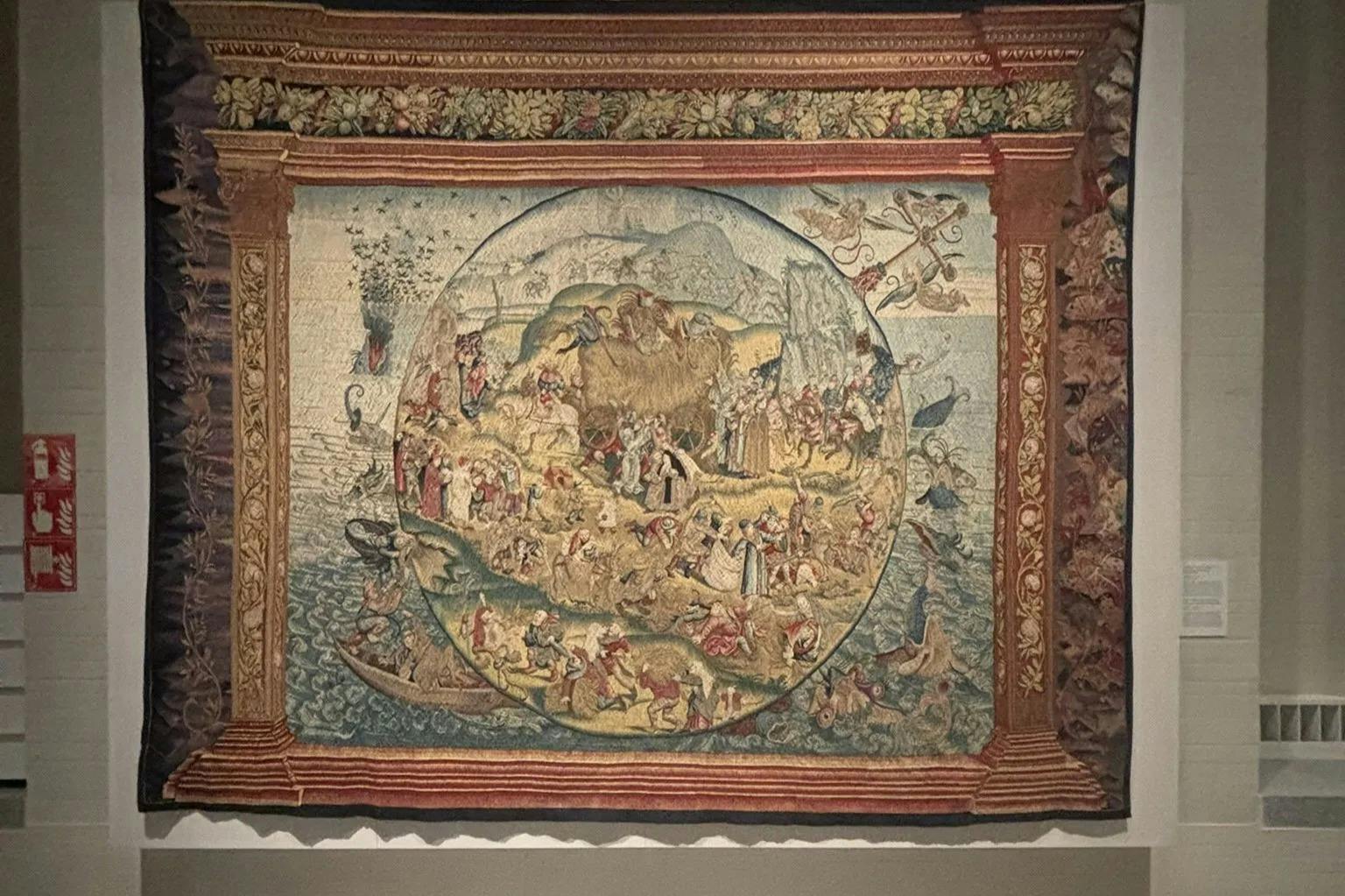 複雑な境界線に囲まれた、さまざまな人、動物、シーンを描いた円形のイラストを描いた華やかなタペストリー。