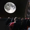 espectadores no adler planetarium apreciando uma projeção da lua e das estrelas