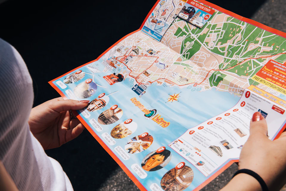 A person holding an open tourist map showing a city layout with marked attractions and a list of guided tour options.