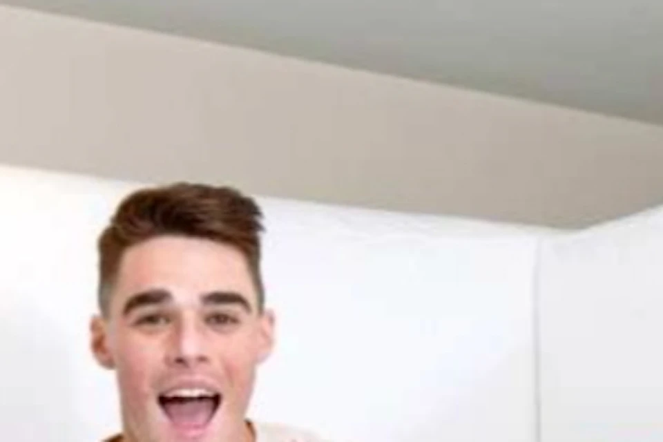 Three people jump joyfully inside a white inflatable room, smiling and wearing casual clothing.