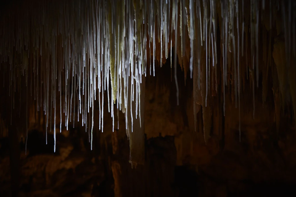 Delicate crystal stalactites hang from the caves ceiling