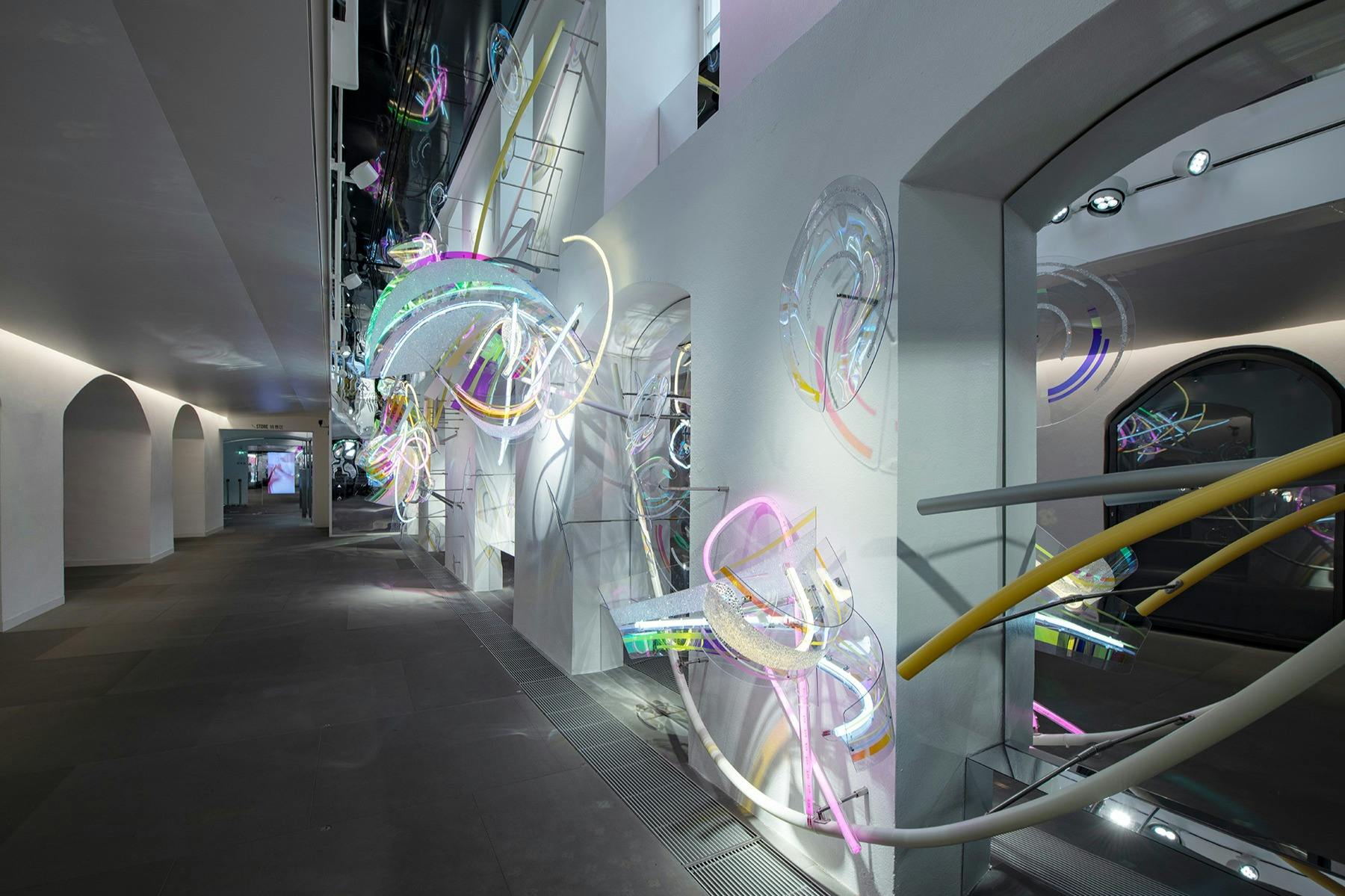 넓은 갤러리의 흰색 벽과 바닥에 화려하고 빛나는 추상적 인 조각품을 갖춘 현대적인 실내 미술 설치.