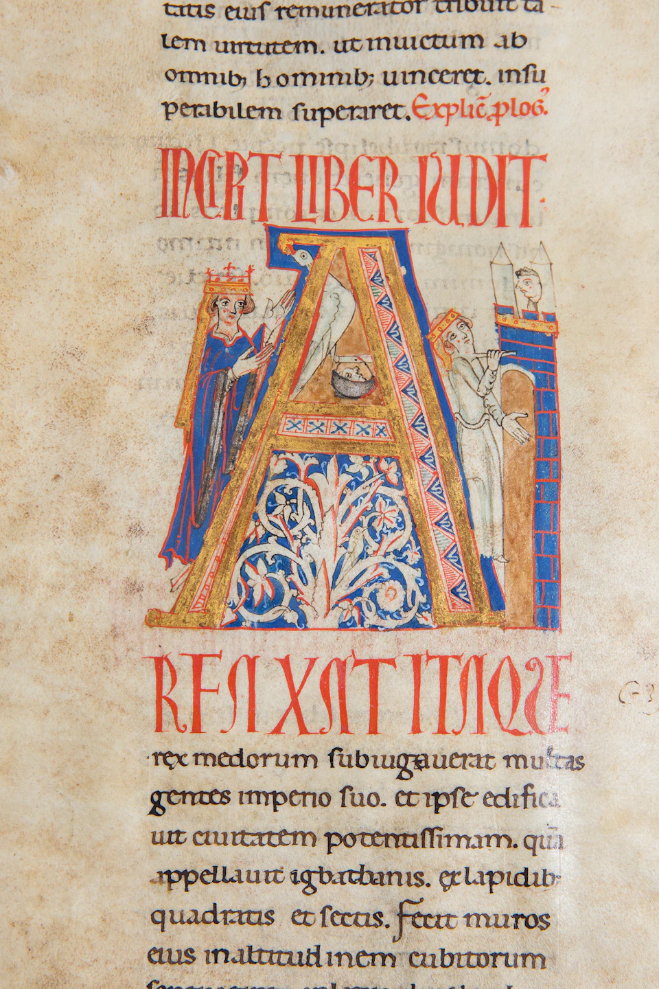 Illuminated manuscript with large letter "A" decorated with intricate patterns, featuring two crowned figures and Latin text underneath.