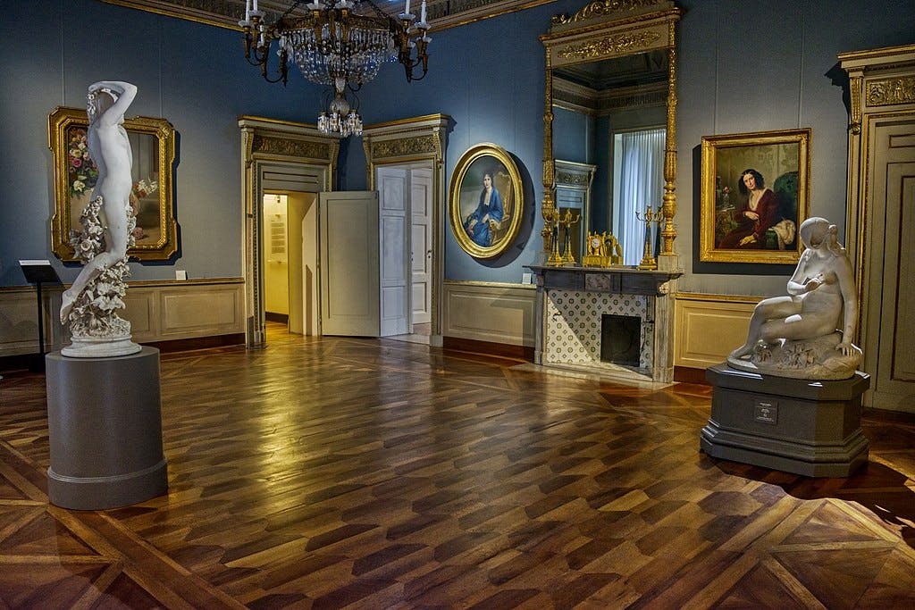 エレガントに装飾された客室には、彫像、額装された絵画、シャンデリアの下にある装飾的な暖炉があります。