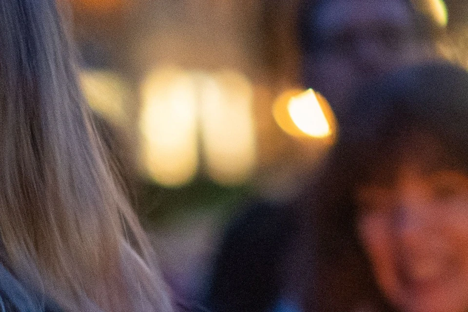 The supplier holds a lantern as guests surround them to listen to ghost stories.