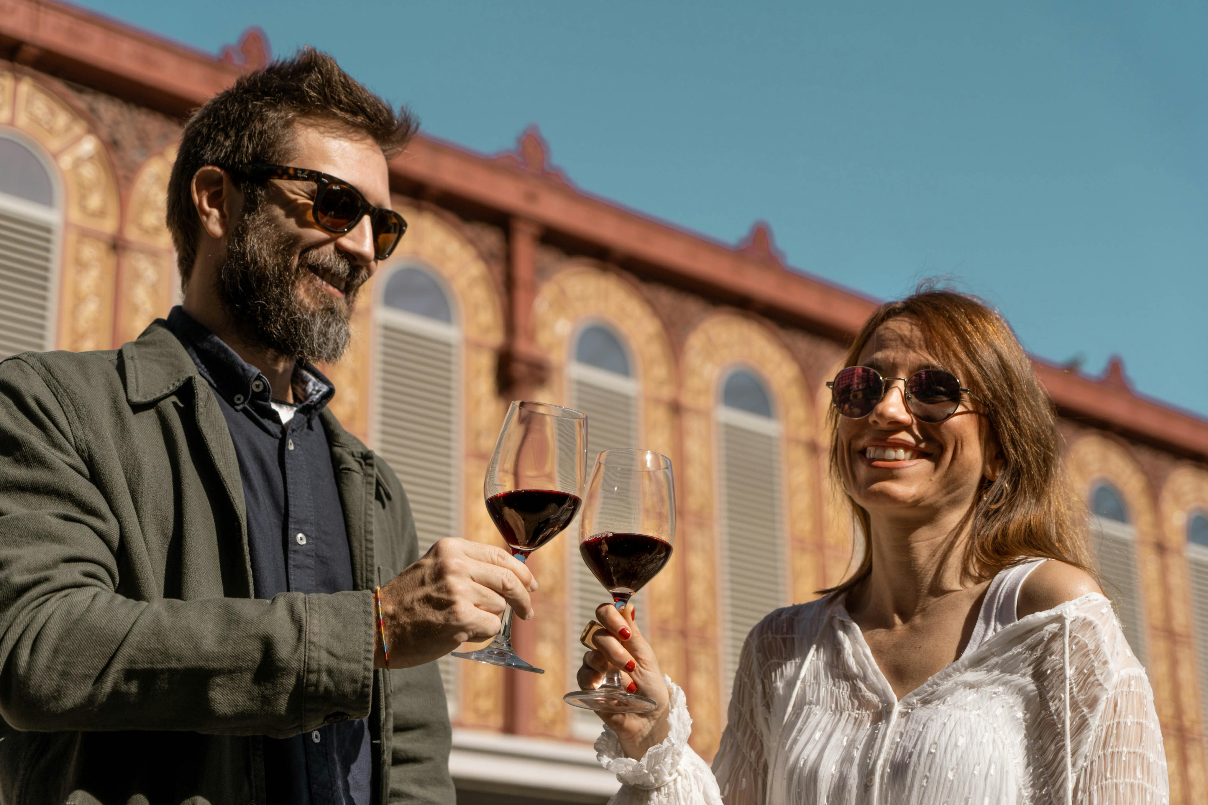 Un homme et une femme tenant un verre de vin lors d'une visite guidée à Barcelone.