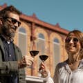 A man and a woman holding a glass of wine while doing a wine tour in Barcelona.