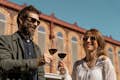 Een man en een vrouw houden een glas wijn vast tijdens een wijntour in Barcelona.