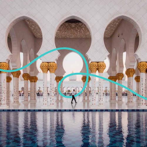 Gyllene och vita utsmyckade pelare återspeglas i en blåkaklad pool, med en välvd pelargång och människor i bakgrunden.
