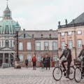 Två personer på cyklar på Amalienborgs torg