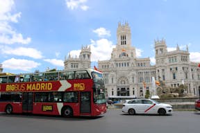 En stor bus kører forbi Cybele Palace i Madrid