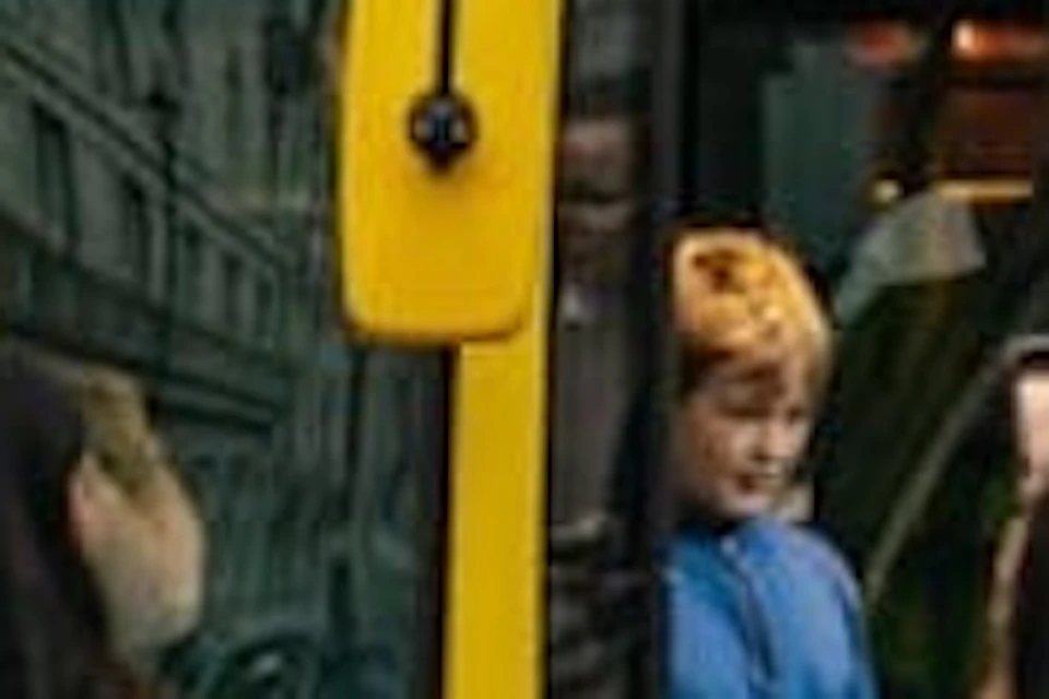 A yellow double-decker bus with "See London by Night" on its display, surrounded by people on a city street.