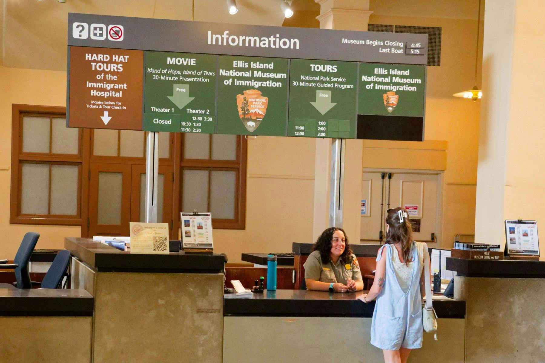 Een bezoeker spreekt met een medewerker bij een informatiebalie in het Ellis Island National Museum of Immigration.