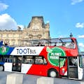 Διώροφο λεωφορείο Tootbus Paris με γαλλικά χρώματα που περνάει από το Λούβρο.