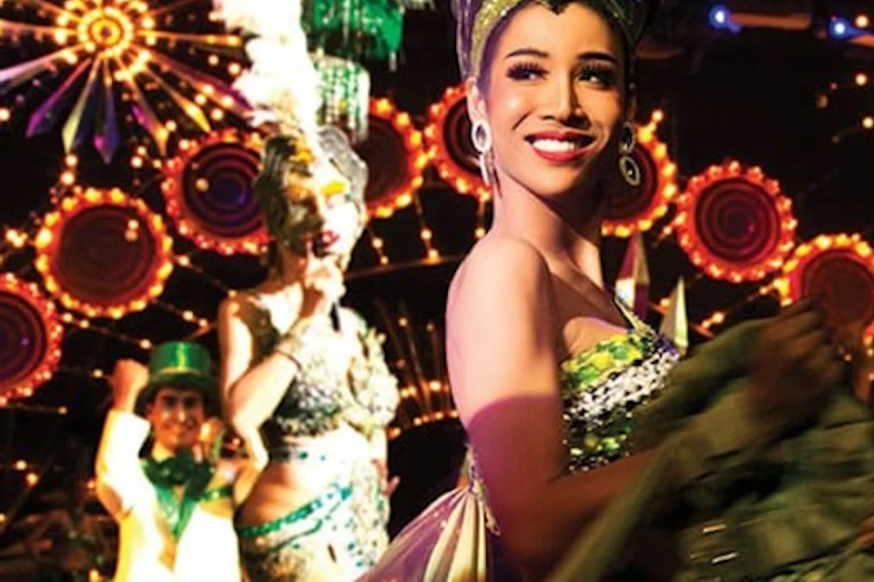 A dazzling performer from Tiffany's Show in Pattaya captivates the audience with her intricate costume and dynamic stage pres