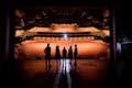 Convidados em um tour pelos bastidores, em pé no Joan Sutherland Stage, olhando para os assentos da plateia