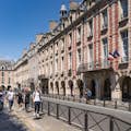 Walking along the Place des Vosges with a guide