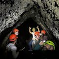 Visita a uma caverna de fluxo de lava com capacetes e tochas