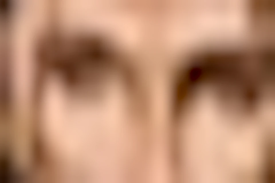 A room with stained glass art depicting musicians, framed pictures on walls, and tables with chairs featuring red upholstery.