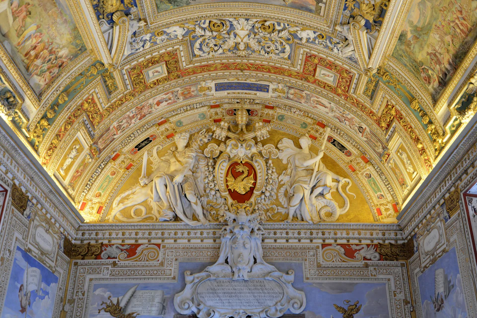 A richly decorated arched ceiling featuring intricate carvings, sculptures, and vibrant gold and red accents.