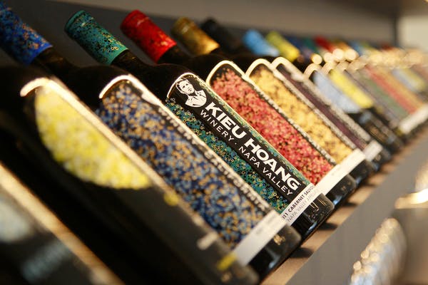 Kieu Hoangワインのボトルが棚に並べられ、それぞれのラベルには鮮やかでカラフルなデザインが施されています。