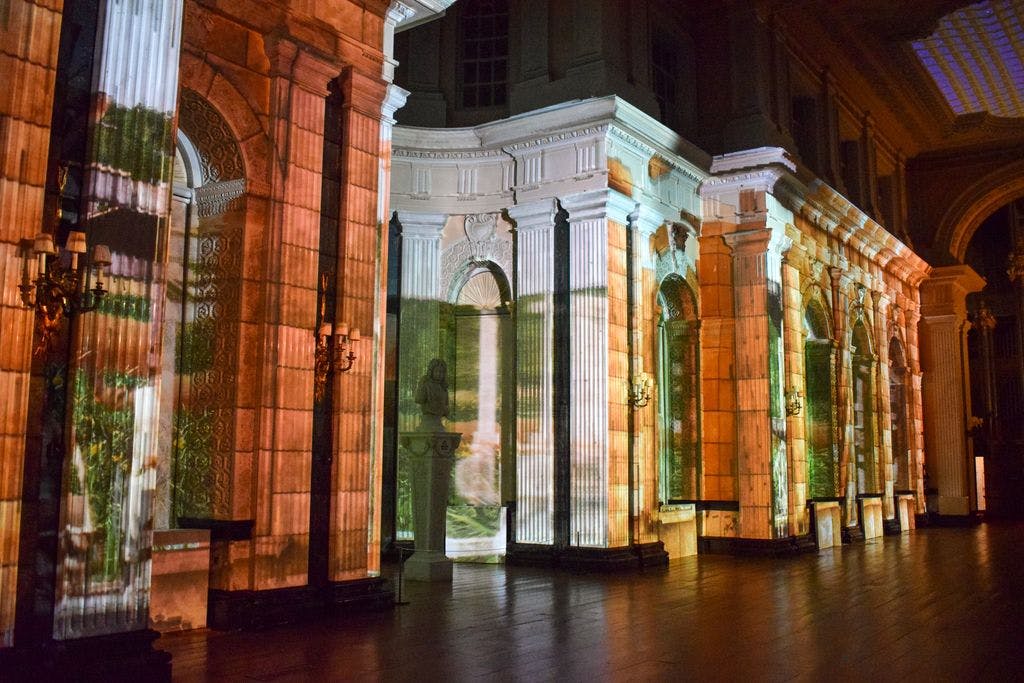 建筑的灯光柱和拱门，色彩缤纷的光线投射在立面上，营造出艺术图案。