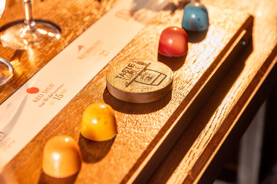 A wooden tray with colorful, dome-shaped chocolates and a wooden token engraved with "MYSTERY LABEL."