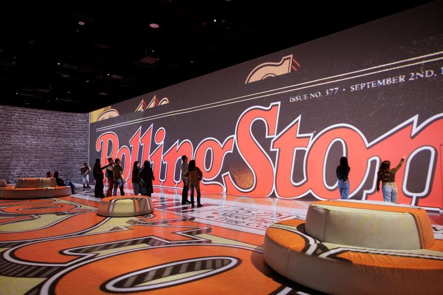 壁と床に投影された大きな「ローリングストーン」雑誌の表紙でインタラクティブな展示を探索します。