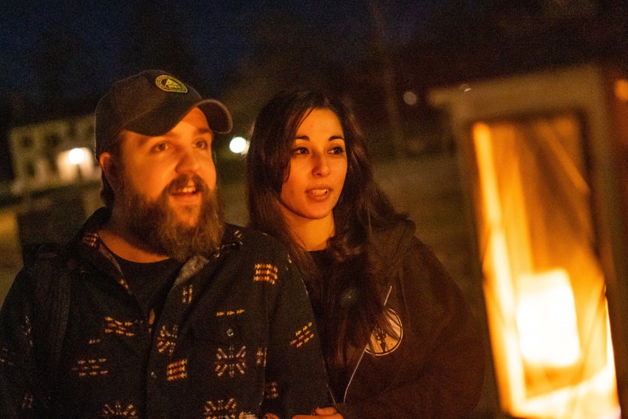 Couple listening to stories next to a lantern