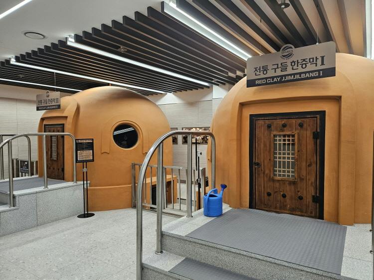 A view of a Korean jjimjilbang with dome-shaped clay sauna rooms labeled "Red Clay Jjimjilbang I."