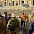Foto di una delle nostre guide che spiega la facciata della Basilica dalla piazza.