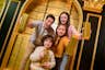 Family hold gold bullion bars whilst standing in Mr. Monopoly's vault
