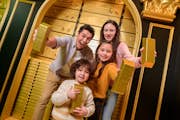 Una familia sostiene lingotes de oro en la cámara acorazada del Sr. Monopoly