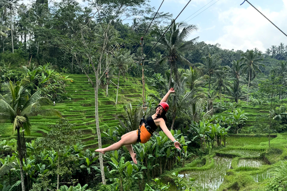 A woman enjoying Zipline happily above the beautiful green rice terraces at U Fun Field Park
