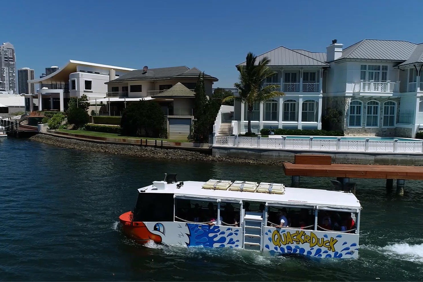 天気のいい日には、カラフルなツアーボート「Quack 'r Duck」が豪華なウォーターフロントの家を通り過ぎます。